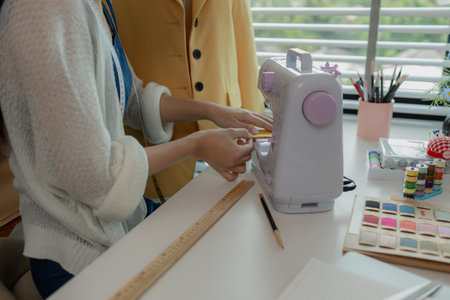 beautiful young lady tailor at work, beautiful female designer at design studio, crop view of fashion designer at work, woman in tailor workshop, clothing designer in workshop.の写真素材