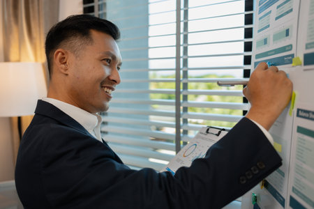 Image of handsome businessman is working in office, cheerful businessman entrepreneur professional working while sitting at office desk, accountant, marketing, employee is working alone in the officeの写真素材