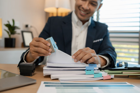 stamped the document to approve, businessman professional working while sitting at office desk, accountant, marketing, employee is working alone in the office, approving report,の写真素材