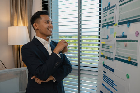 Image of handsome businessman is working in office, cheerful businessman entrepreneur professional working while sitting at office desk, accountant, marketing, employee is working alone in the officeの写真素材