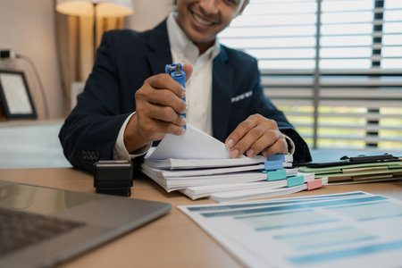 stamped the document to approve, businessman professional working while sitting at office desk, accountant, marketing, employee is working alone in the office, approving report,の写真素材