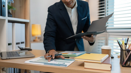 Image of handsome businessman is working in office, cheerful businessman entrepreneur professional working while sitting at office desk, accountant, marketing, employee is working alone in the officeの写真素材