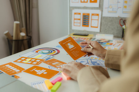 A team of web developers discusses how to best organize a website layout. They share ideas on how to best optimize a digital product, ux ui team is working together in the officeの写真素材