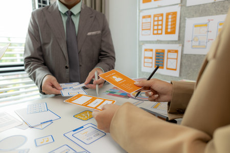 Digital product designers exchange ideas in their offices about how to design a website that meets the needs of today's users, who focus on ease of use and beautiful colors.の写真素材