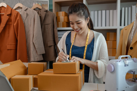 a designer is preparing products to send to customers by mail, a female dressmaker is selling her products online to increase her income, female industrial tailor at workの写真素材