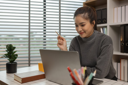 happy woman working on laptop at home office, entrepreneur using laptop at home office, mature businesswoman working from home, beautiful company owner working during isolation periodの写真素材