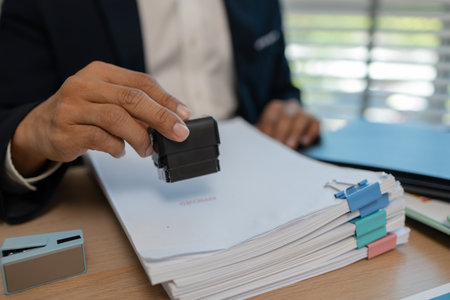 stamped the document to approve, businessman professional working while sitting at office desk, accountant, marketing, employee is working alone in the office, approving report,の写真素材
