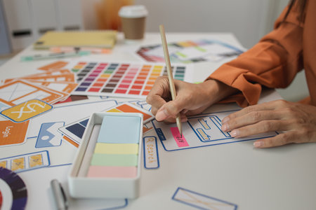 UI UX designers team working on new website wireframe in office, ux developer and ui designer use augmented reality brainstorming about mobile app interface wireframe design on desk at modern officeの写真素材