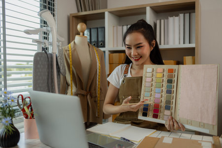 a beautiful female tailor is consulting and talking with a customer to make an agreement that the proposed clothing style matches the customer's requirements, designer, entrepreneur, sewingの写真素材