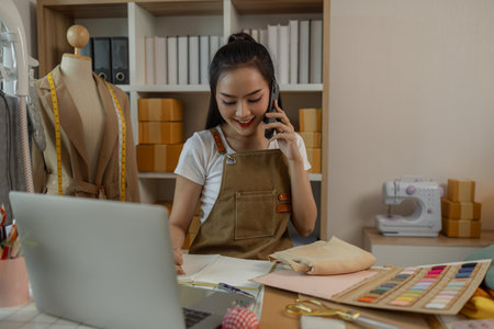 a beautiful female tailor is consulting and talking with a customer to make an agreement that the proposed clothing style matches the customer's requirements, designer, entrepreneur, sewingの写真素材