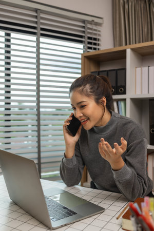 happy woman working on laptop at home office, entrepreneur using laptop at home office, mature businesswoman working from home, beautiful company owner working during isolation periodの写真素材