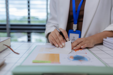 an employee sits working in an office full of documents that need to be completed on time, the...