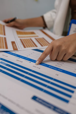 there are a lot if documents pied up on the desk if the data analysis team leader, an employee sits working in an office full of documents that need to be completed on timeの写真素材