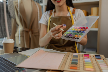 a beautiful female tailor is consulting and talking with a customer to make an agreement that the proposed clothing style matches the customer's requirements, designer, entrepreneur, sewingの写真素材