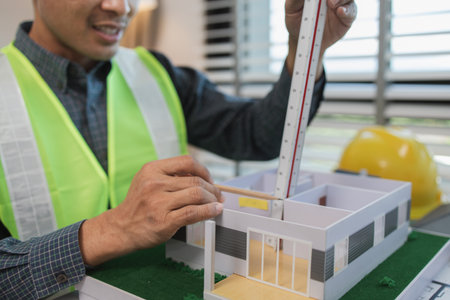 businessman or architect with model of a house working in office, architect working in office with blueprints, engineer inspect architectural plan, sketching a construction project, business concept,の写真素材