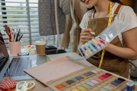 a beautiful female tailor is consulting and talking with a customer to make an agreement that the proposed clothing style matches the customer's requirements, designer, entrepreneur, sewingの写真素材
