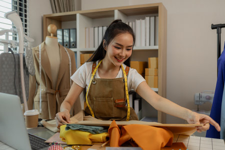 a beautiful tailor is working on her favorite craft in a studio filled with a variety of sewing supplies, fabrics and threads, designer, dressmaker, fashion, entrepreneurの写真素材