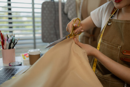 a beautiful tailor is working on her favorite craft in a studio filled with a variety of sewing supplies, fabrics and threads, designer, dressmaker, fashion, entrepreneurの写真素材