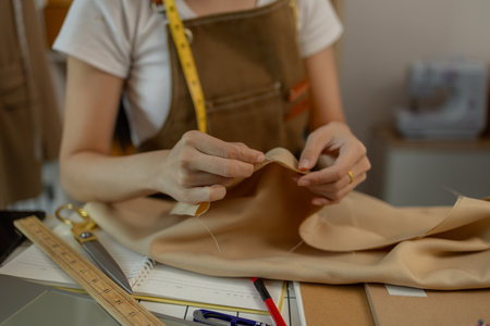 a beautiful female tailor is consulting and talking with a customer to make an agreement that the...