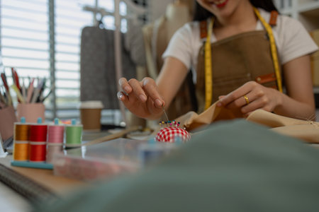 a beautiful female tailor is consulting and talking with a customer to make an agreement that the proposed clothing style matches the customer's requirementsの写真素材