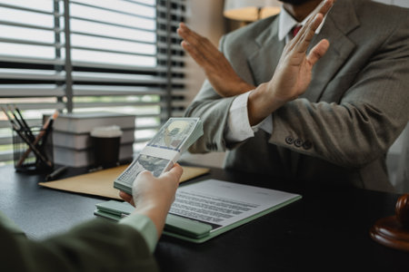 a client attempted to bribe the opposing party's lawyer in order to win a court case, an ethical lawyer refuses to accept money from his client's opposing party, corruption, illegalの写真素材