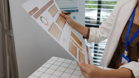 there are a lot of documents piled up on the desk of the data analysis team leader, an employee sits...