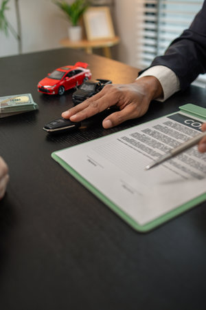 a car salesperson is explaining the details of a car purchase contract to the buyer before signing...