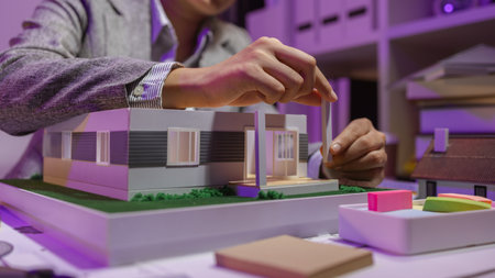 a passionate female architect works in her private office to remodel a house to meet her client's exact needs and meet construction deadlines, house model, engineer, blueprintの写真素材