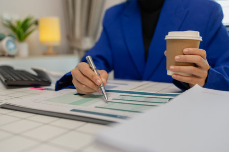 businesswoman is working in her private office with a lot of paperwork, head of marketing and financial department, an entrepreneur, meeting room, a lot of paperwork on the deskの写真素材