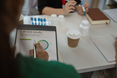 the three doctors are meeting to exchange new knowledge and information they have gained form their medical seminars with each other, a senior doctor is explaining information and knowledgeの写真素材