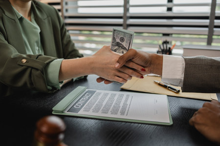 lawyer and client shake hands after receiving bribes for illegal deals, a client is bribing the...