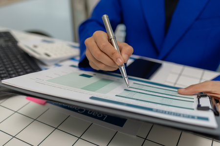 concentrated female entrepreneur working on paperwork while sitting at desk in office, businesswoman...