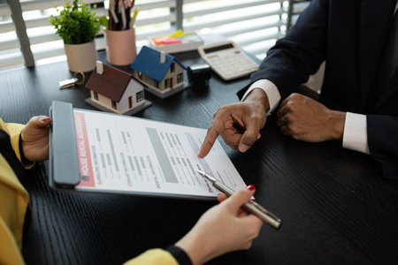 the staff is explaining the details of the rental contract to the tenant, which includes the prohibitions and rights in the house, property, rent, estate, investment, homeの写真素材