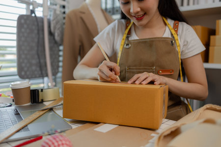 a woman fashion shop owner is live-streaming to chat with customers and pack her products into boxes...