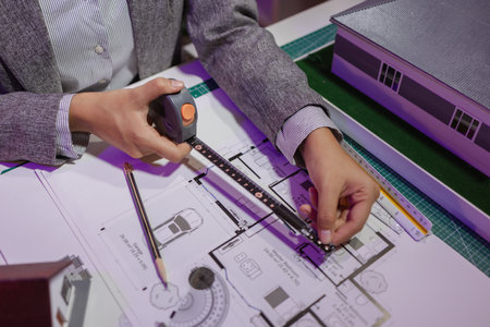 a beautiful female architect is working in her private office because she needs to concentrate on improving the blueprints to be in accordance with the law, engineer, foreman, contractorの写真素材