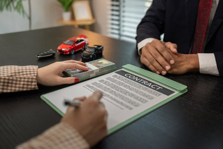 a car salesperson is explaining the details of a car purchase contract to the buyer before signing the sales contract, showroom, dealer, car contract, sining a car purchase contractの写真素材