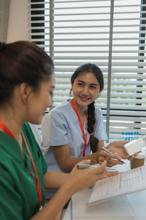 two doctors are meeting to exchange new knowledge and information they have gained form their medical seminars with each other, a senior doctor is explaining information and knowledgeの写真素材