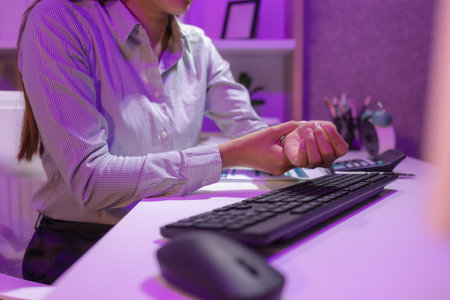 an employee sits in the office for a long time because she has to work overtime because there is a lot of pending work, which causes office syndrome, tired, businesswoman, syndromeの写真素材