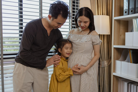 the happy family is excited to meet their new member soon as the mother is about to give birth to the youngest child of the family, enjoyment, pregnant, parent, daughterの写真素材