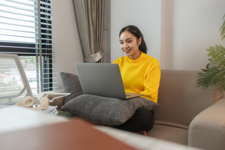a woman is spending her holiday in the living room of her house, feeling peaceful and happy because she has done many activities that make her feel relaxed, sofa, couchの写真素材