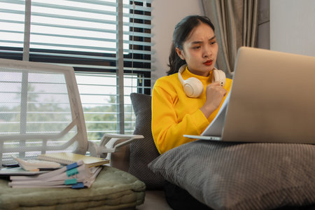 a businesswoman is working at home on the weekend, an employee had to take work home because there were so many documents she had to edit that she couldn't finish them in her working hoursの写真素材