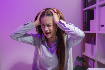 a female supervisor is working overtime at the company stressed because there are many documents that need to be solved in time, tired, businesswoman, deadline, overwork, exhaustedの写真素材
