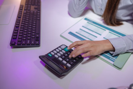 a businesswoman works overtime at her company to finish important documents in time for a business cooperation contract signing tomorrow, tired, overworked, deadlineの写真素材