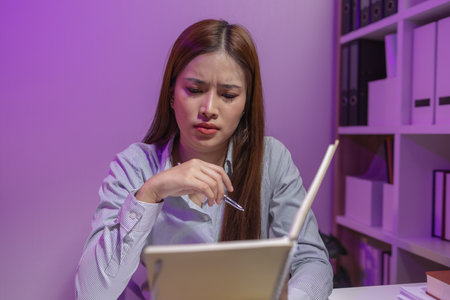 this businesswoman was sitting in her private office working and lost track of time because of the amount of work she had to do, overtime, overwork, tired, overworked, troubleの写真素材