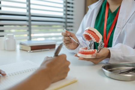 the dentist is explaining to the assistant how she will treat a patient with wisdom teeth, the two dentists discussed the treatment plan for the patient with root canal treatmentの写真素材
