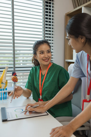 consultation between two doctors in the office, two medical students are discussing treatment guidelines for a patient assigned to them by a senior physician, nurse, brainstorming, hospitalの写真素材