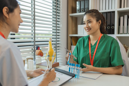 consultation between two doctors in the office, two medical students are discussing treatment guidelines for a patient assigned to them by a senior physician, nurse, brainstorming, hospitalの写真素材