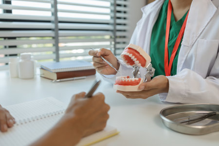 the dentist is explaining to the assistant how she will treat a patient with wisdom teeth, the two dentists discussed the treatment plan for the patient with root canal treatmentの写真素材