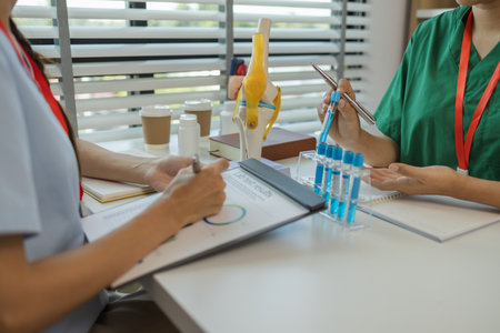 consultation between two doctors in the office, two medical students are discussing treatment guidelines for a patient assigned to them by a senior physician, nurse, brainstorming, hospitalの写真素材