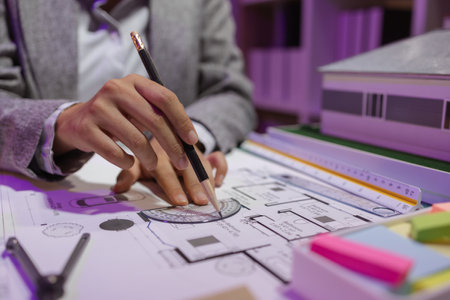 a beautiful female architect is working in her private office because she needs to concentrate on improving the blueprints to be in accordance with the law, engineer, foreman, contractorの写真素材